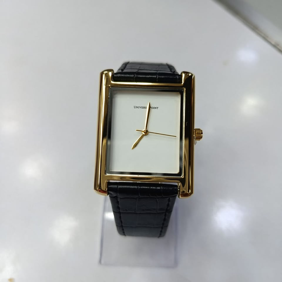 A rectangular analog watch with a gold-tone case, white dial, and black leather strap, displayed on a clear stand against a white background.